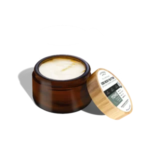 Manteiga corporal CBD da Cannabidiol Life. Está em um frasco de vidro marrom âmbar, com a borda aberta, apresentando a textura sedosa, orgânica e amanteigada branca.